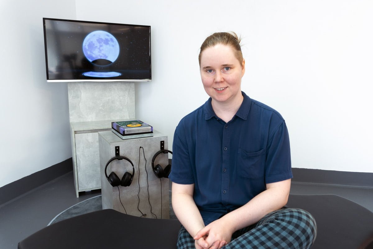 Photo of artist Lauren Edmonds with their artwork Dark Forebodings (2024)